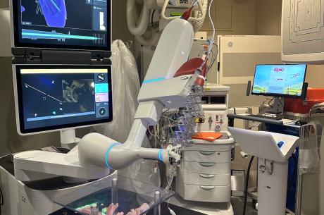 The large, white ION Robotic arm is positioned over a replica of the lungs on a black table