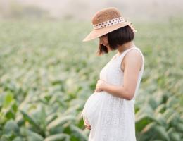 pregnant woman outdoors in a grassy area