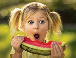 Young girl eating a watermelon