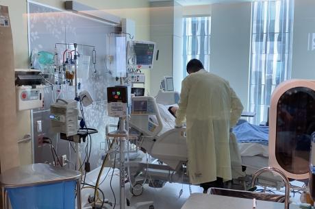 Dr. Tan speaks with a COVID patient in the Dennis and Carol Troesh Medical Campus MICU