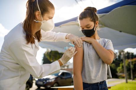 female physician vaccinates teenage girl